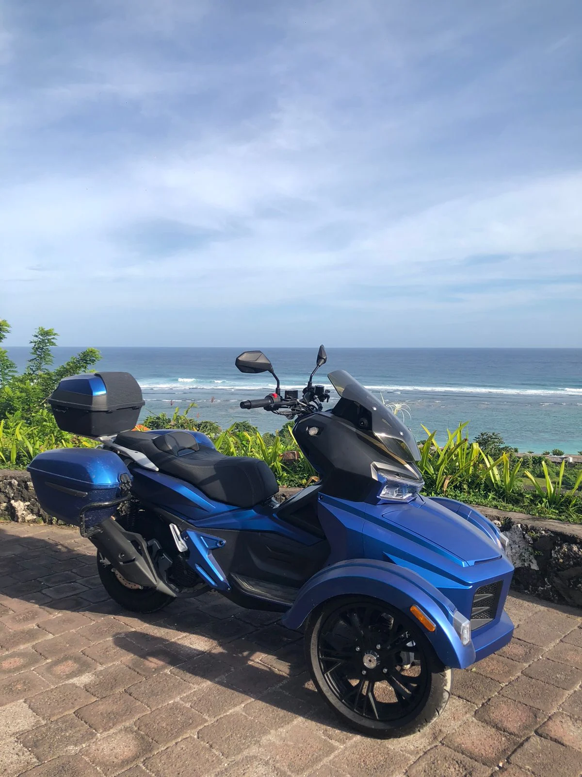 A blue Moratti parked beside the coastline